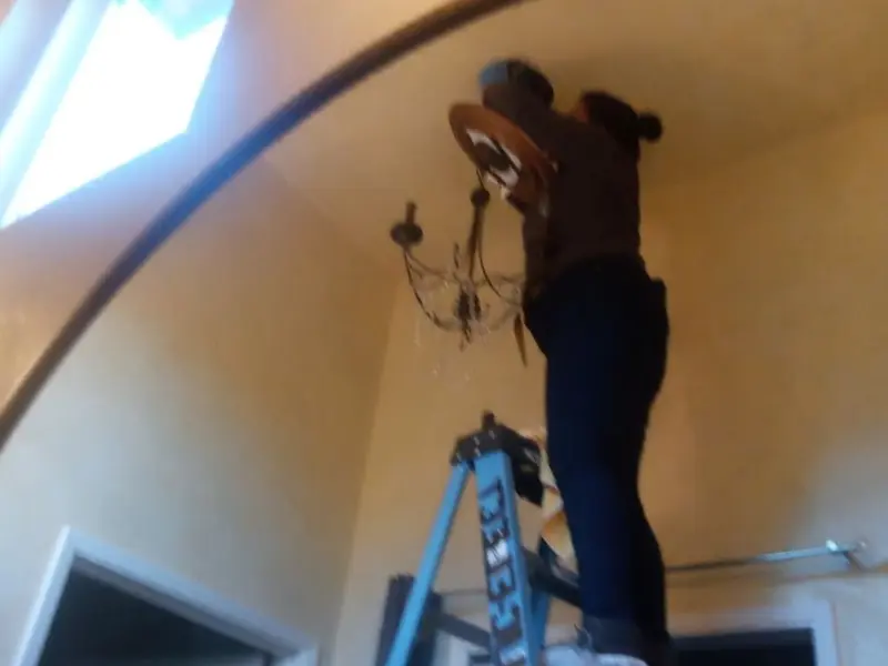 Electrician installing a chandelier in a Surprise residence